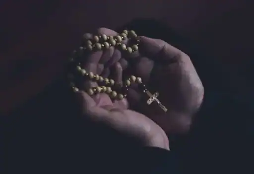 open hands holding rosary