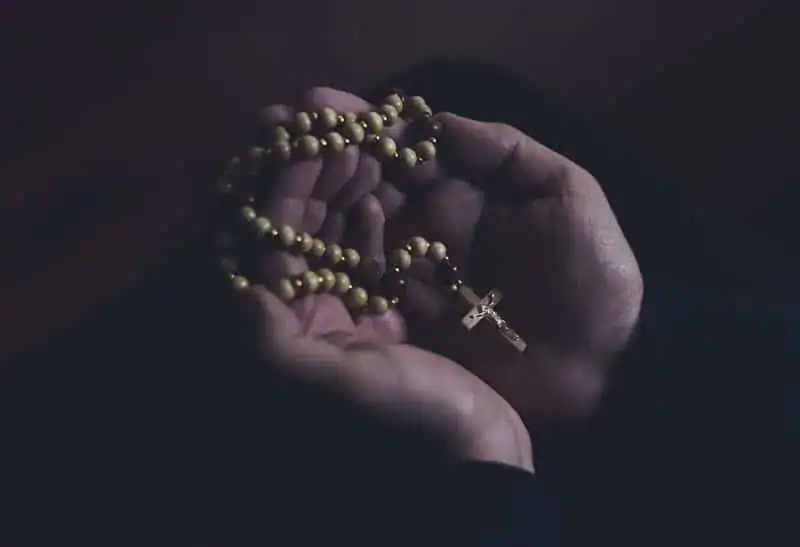 open hands holding rosary