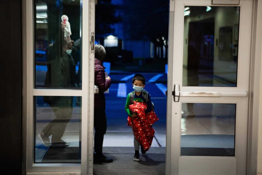 Early learning student carrying jacket into first day back at school