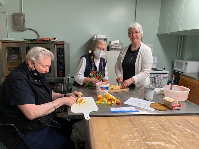 Sisters in the kitchen cutting fruit