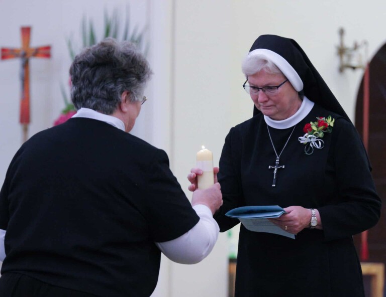 Sister Michael Francine receives a candle from Sister Charlene Herinckx