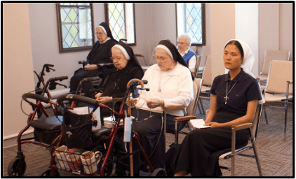 Sister Truc Grace leading the rosary in the third floor chapel.