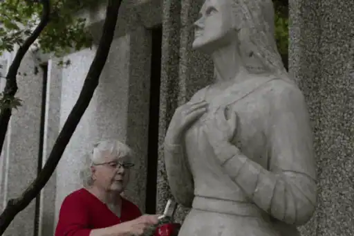 Barbara Hertel cleaning Mary the statue