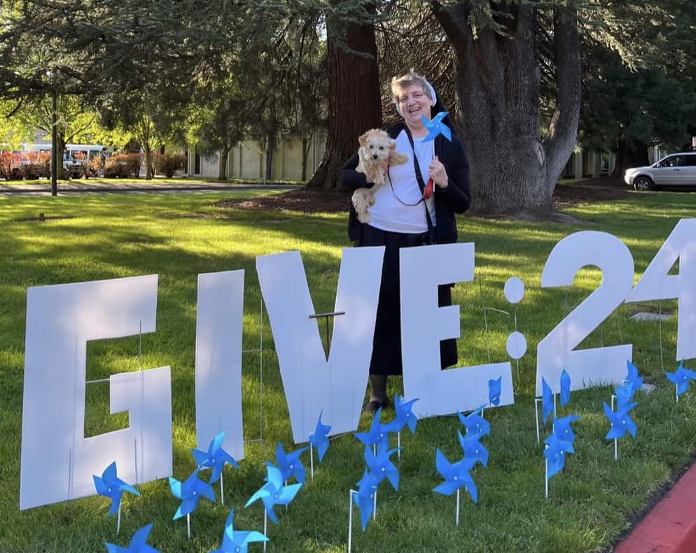Sister Adele Marie Altenhofen with "Give 24" cutout yard sign