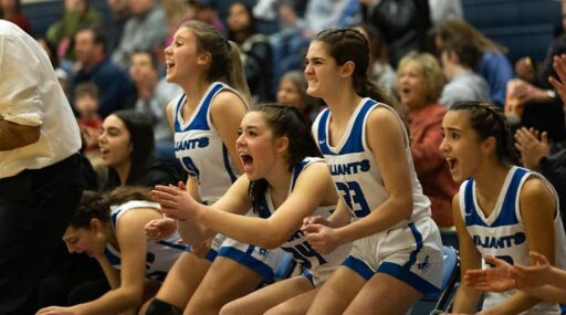 Celebrating girls basketball team on sidelines