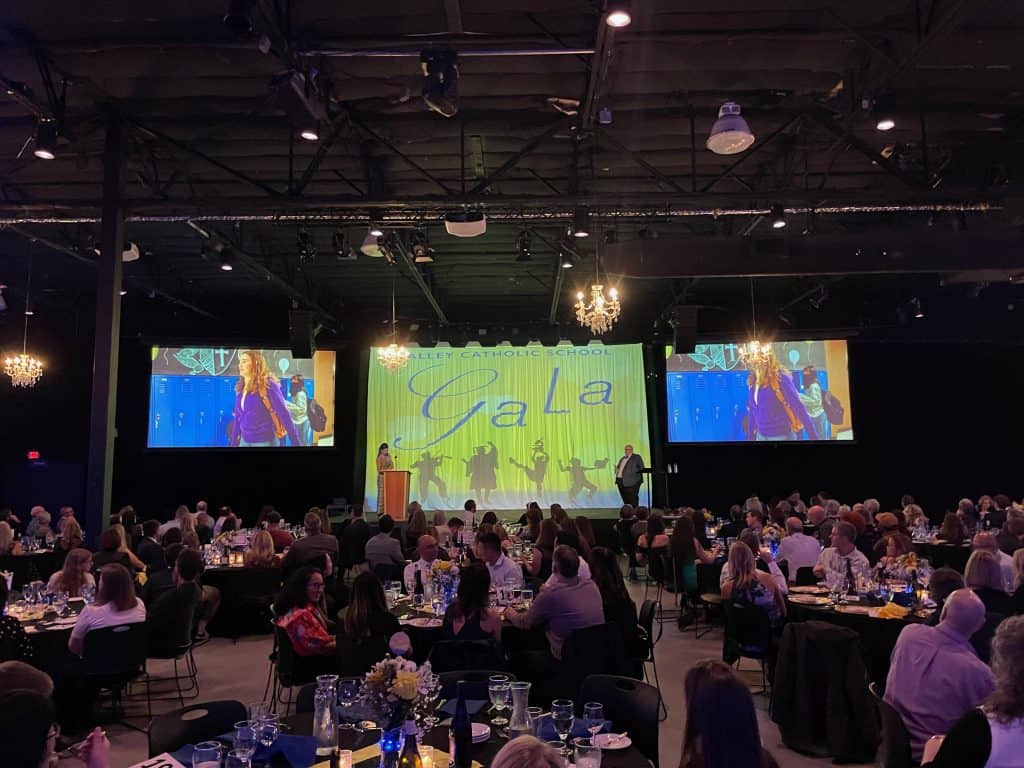 Larger view of Gala event; full tables, watching video playing
