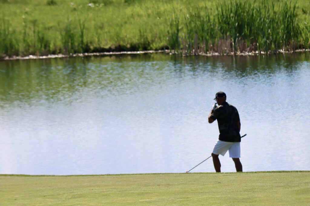 Golfer looking for his ball in the pond