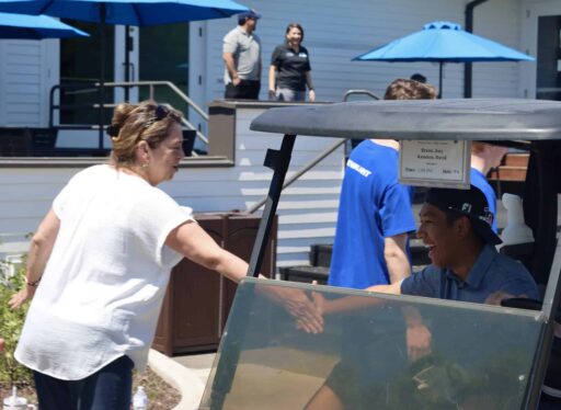 Golfers on golf carts being greeted