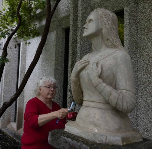 Barbara Hertel cleaning Mary statue
