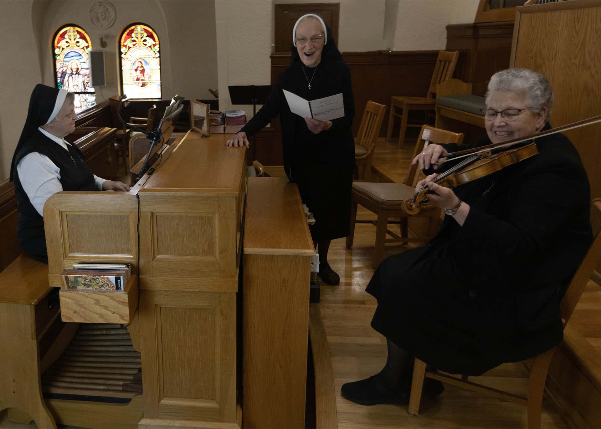 Srs. Juliana, John Therese, and Denise enjoying playing music and singing in the Motherhouse Chapel