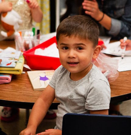 Early learning boy at activity, craft desk