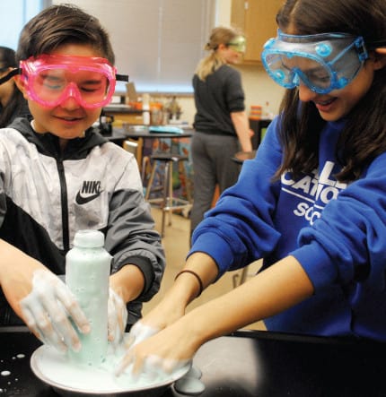 Middle school students with safety googles mid activity