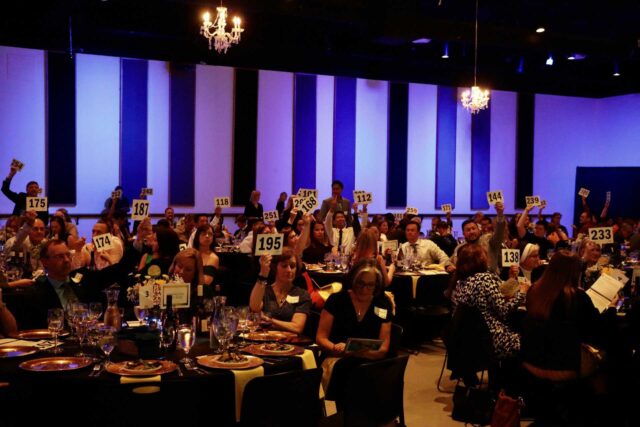 Gala attendees with paddles raised