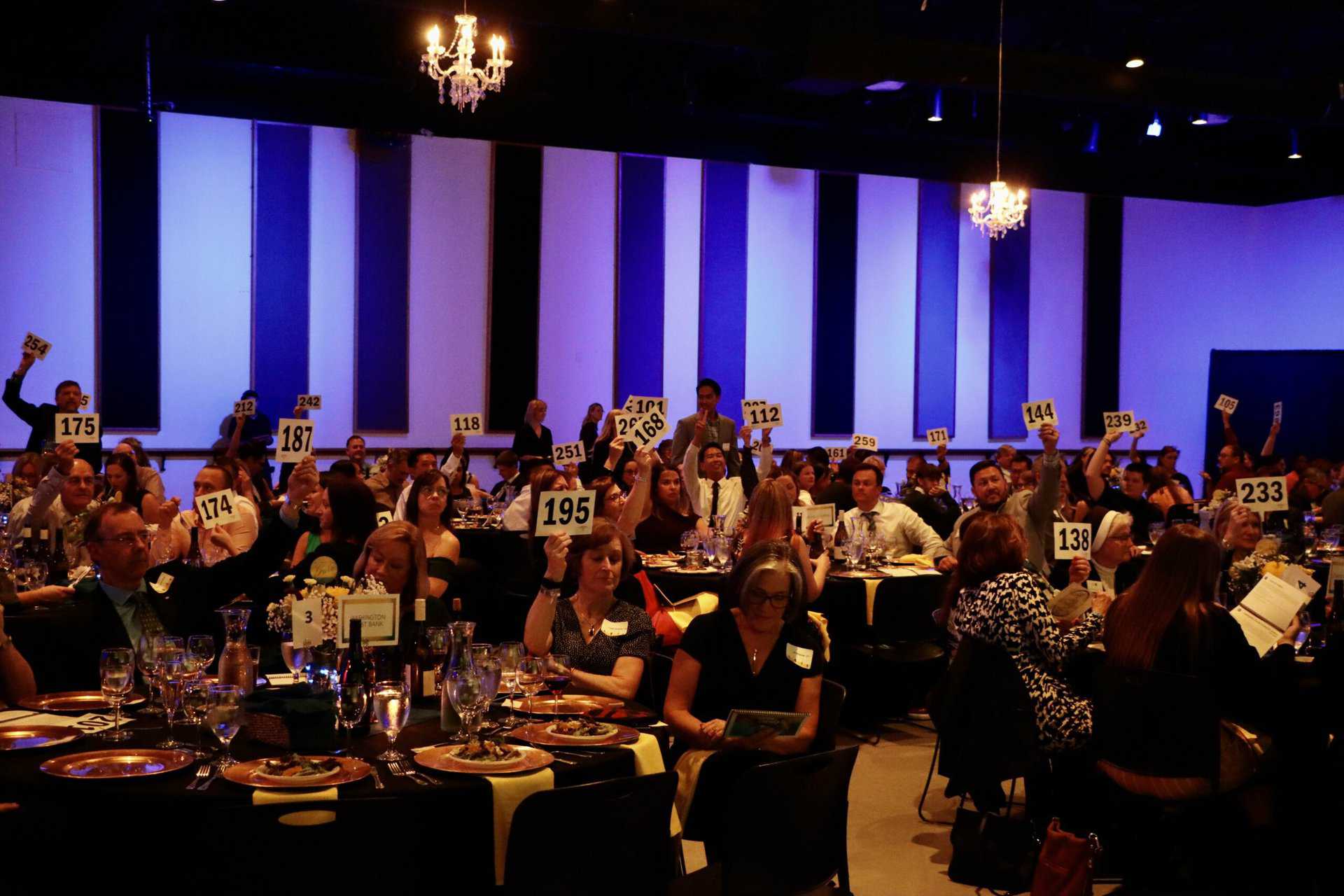 Gala attendees with paddles raised