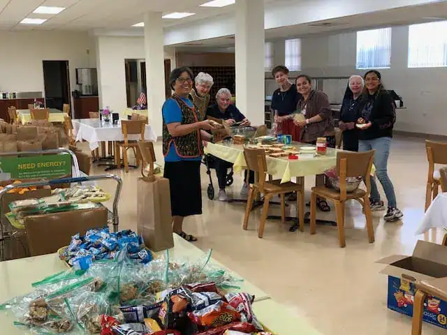 Sisters putting lunches together for women's shelter