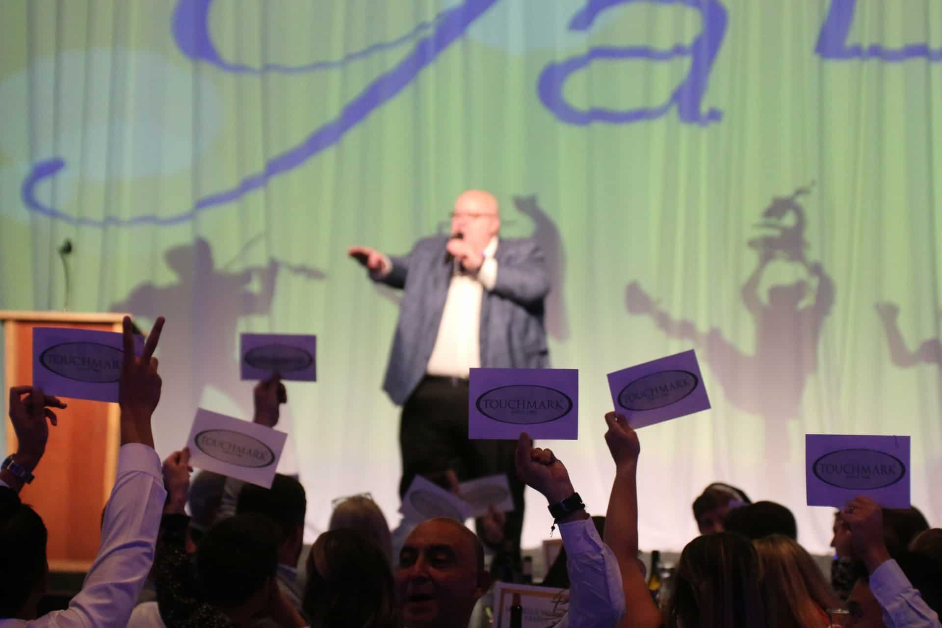 Auctioneer calling paddle numbers during Gala giving