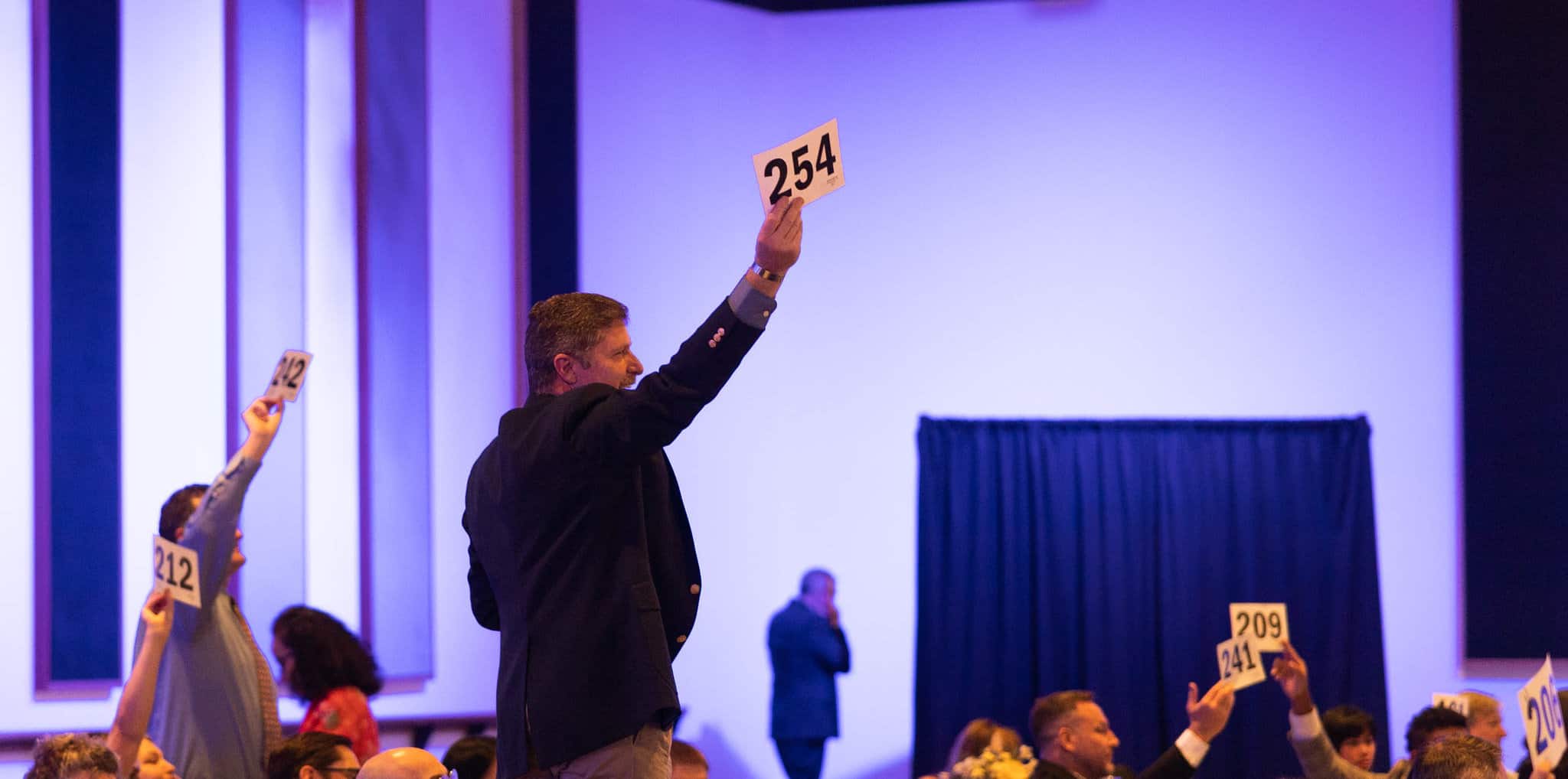 Bidder standing during Gala auction