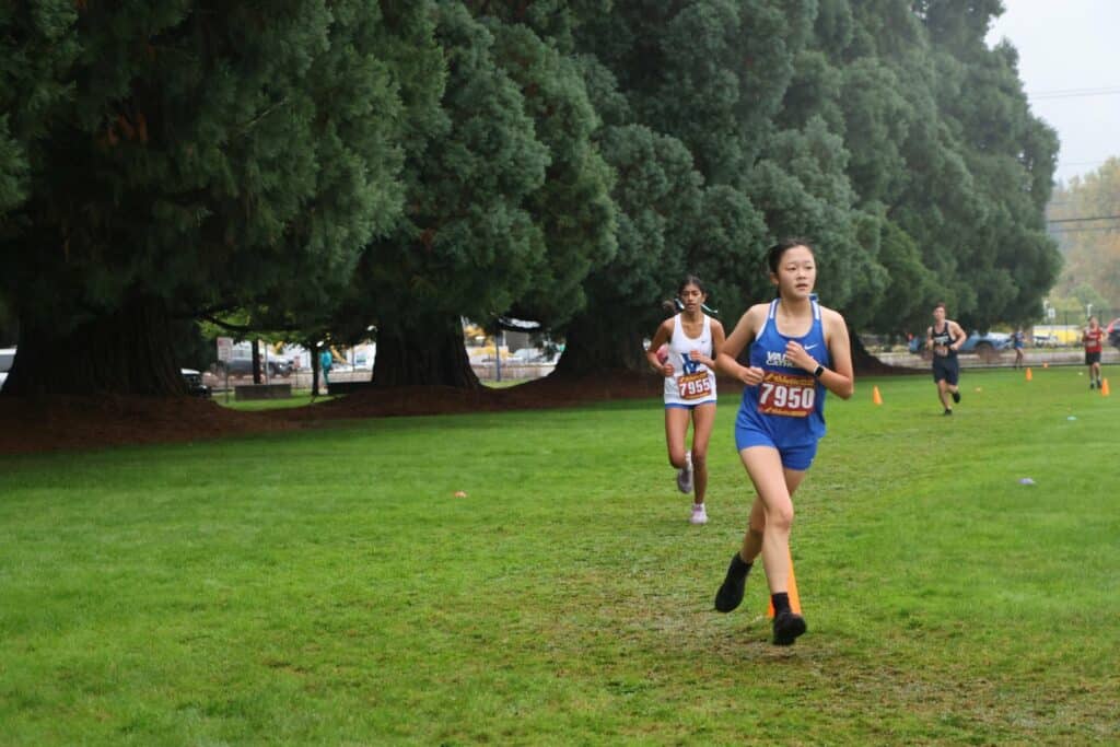 CC girls running past campus sequoias