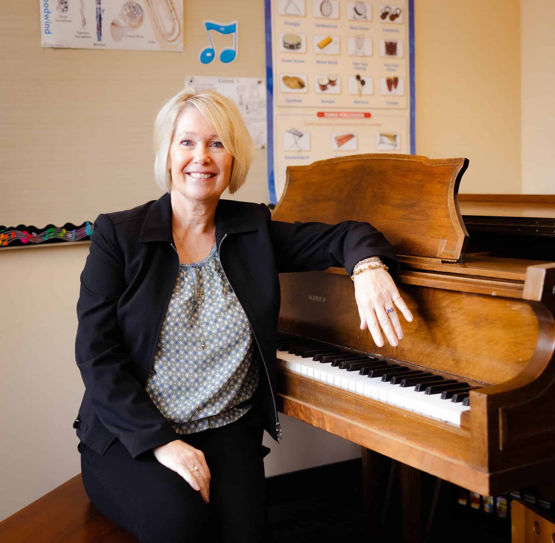 Beckie Hocker, V C Music School Director, sitting at the piano