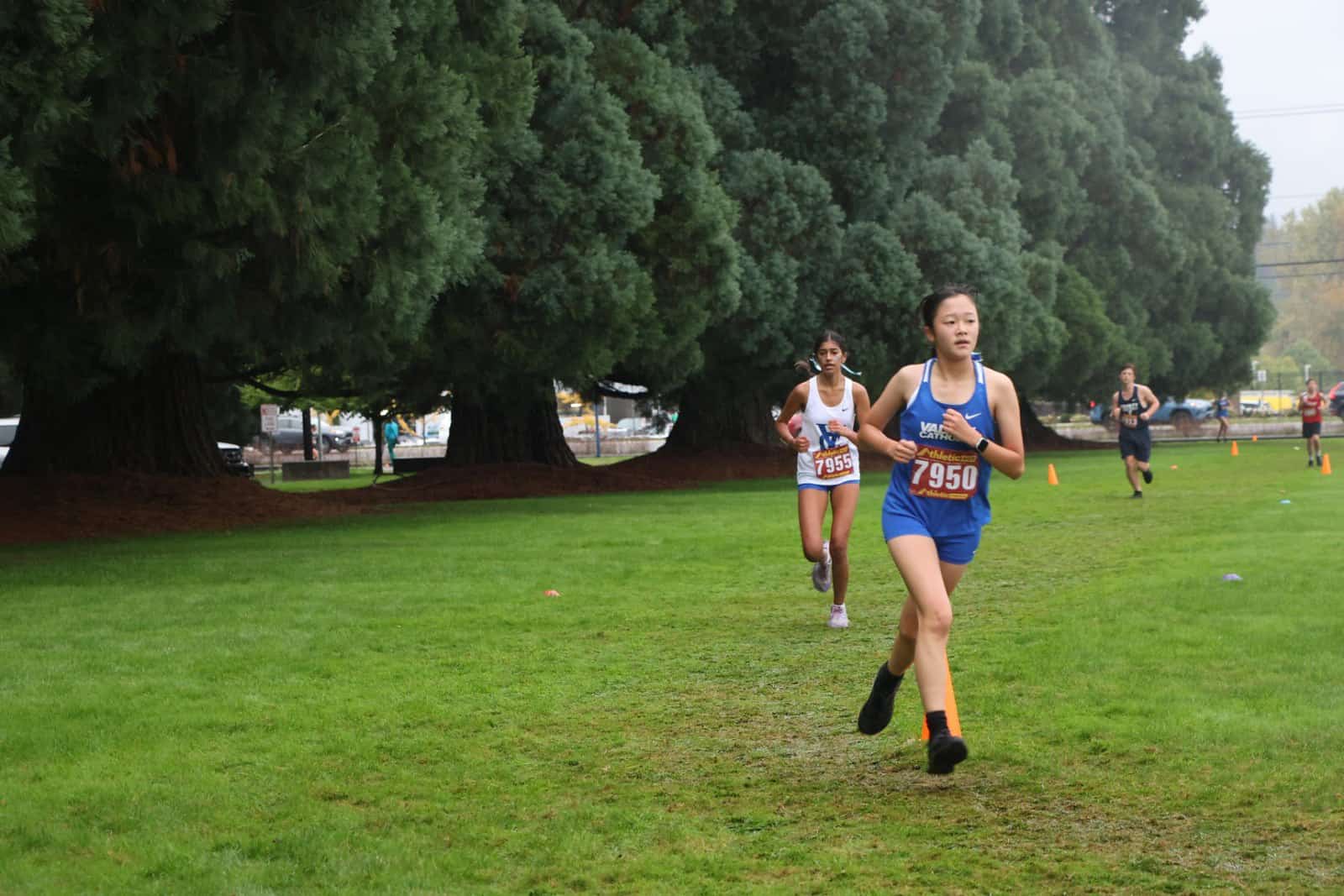 C C girls running past campus sequoias