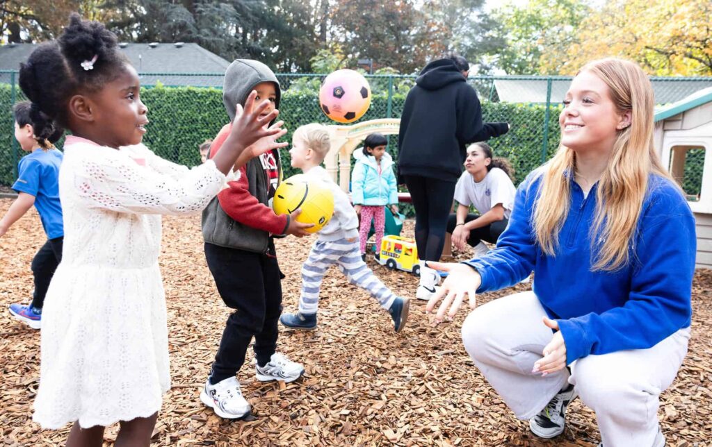 Early Learning and High School students tossing a ball
