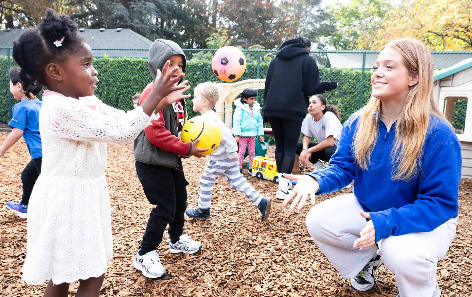 Early Learning and High School students tossing a ball