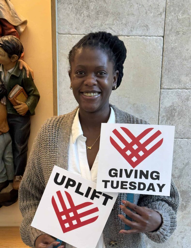 Dr. Yvonne Ayesiga with Giving Tuesday uplift heart signs