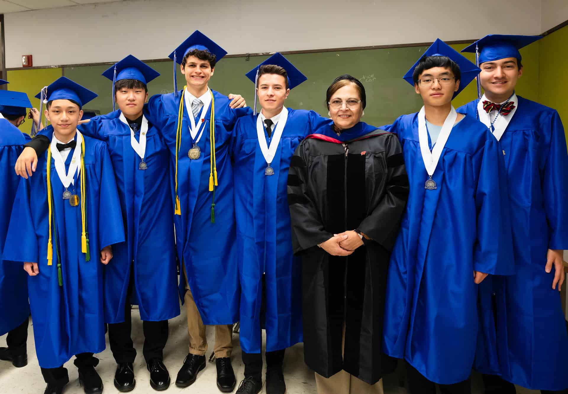 Graduates posing with their teacher