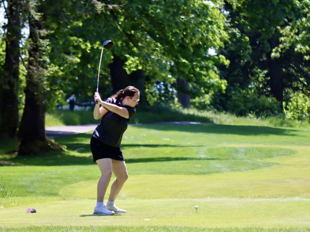 VC student teeing off at Whole in One Golf