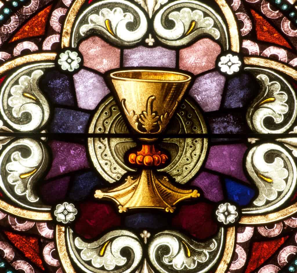 Stained glass window depicting a golden chalice and Paten