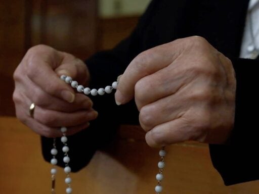 Sister's hands while holding on to and praying the rosary