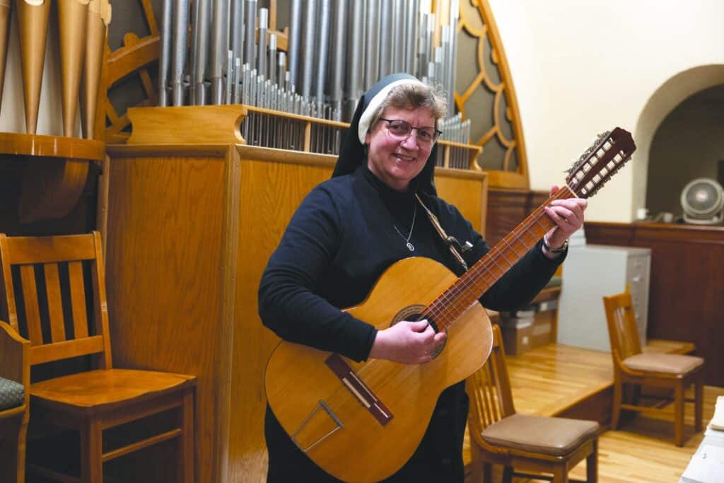 Sr. Adele Marie holding her 12 string guitar