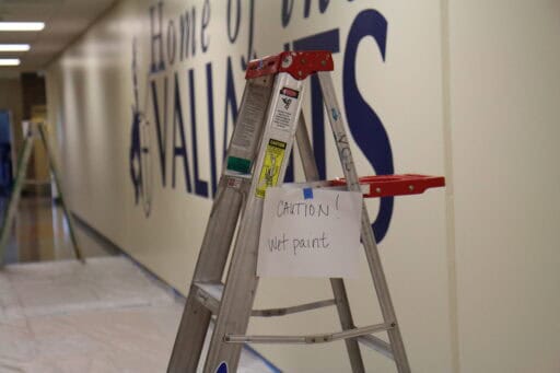 Wet paint sign in front of valiants mural