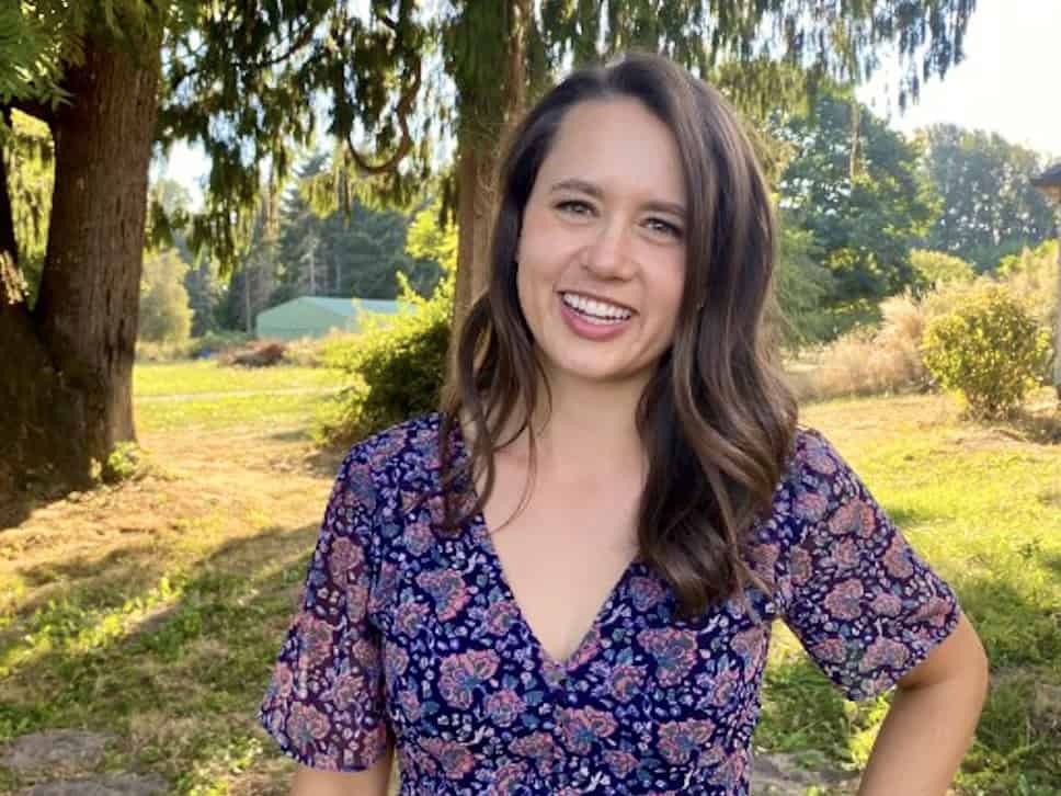Greta Jarvis is outside wearing a purple dress with flowers.