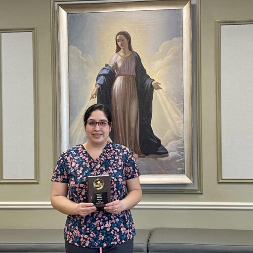 Maria Rivera, CNA- Employee of the Month for March, holding her plaque