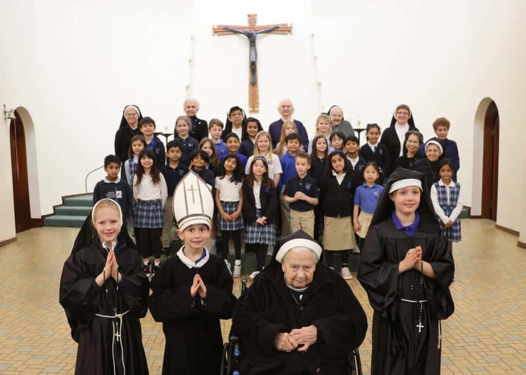 Second graders wear nun and priest costumes for program about the Sisters' history.
