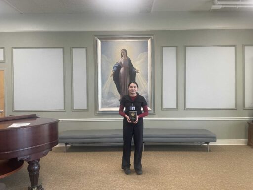 Dulce Santana Moterreso, Maryville's Employee of the Month for April. Holding her plaque.