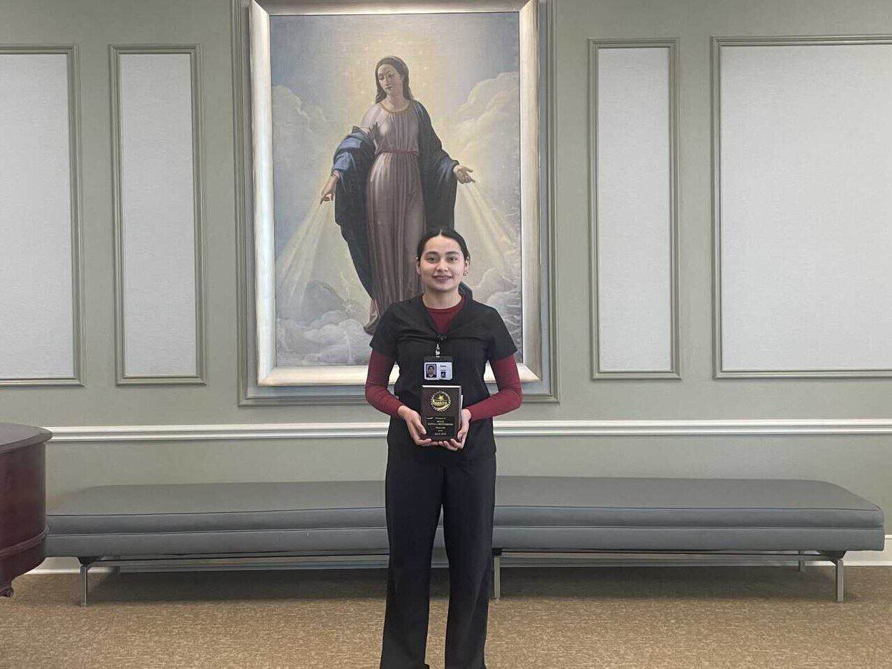 Dulce Santana Moterreso, Maryville's Employee of the Month for April. Holding her plaque.