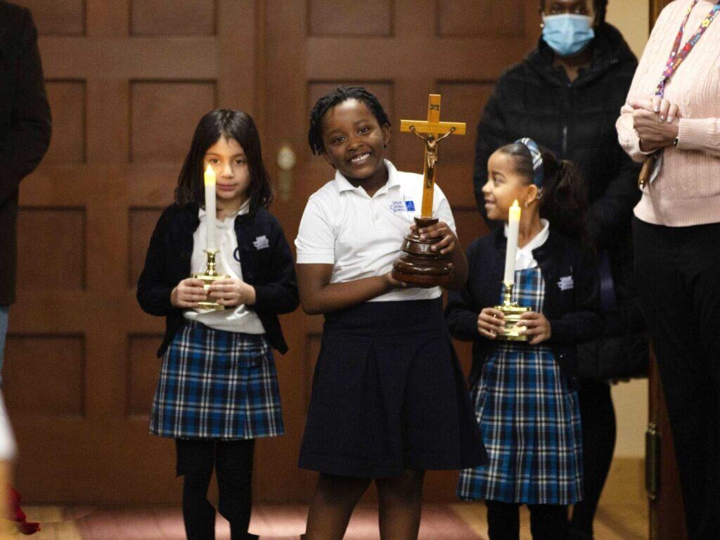 Three vces students walking down aisle in motherhouse chapel