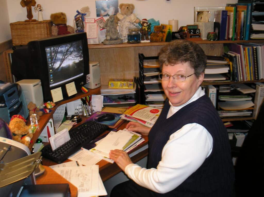 Sr. Ruth Frank working at her desk with a computer