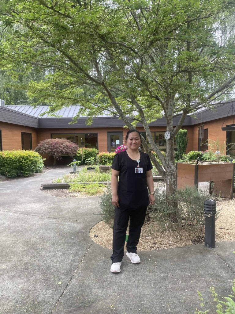 June 2026 Employee Of the Month, Ma Lopretti "Pretti" posing in the courtyard