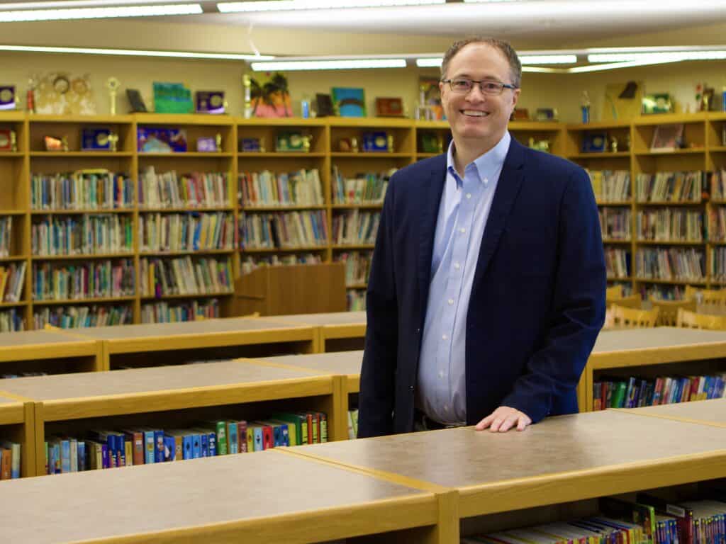 Dr. Judd Case, VCS President, standing in the library.