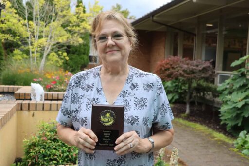 Sarah Kuni, RN - Maryville’s Employee of the Month for September. In the garden holding her plaque.