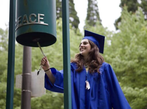 During Senior Walk a female student rings the peace bell