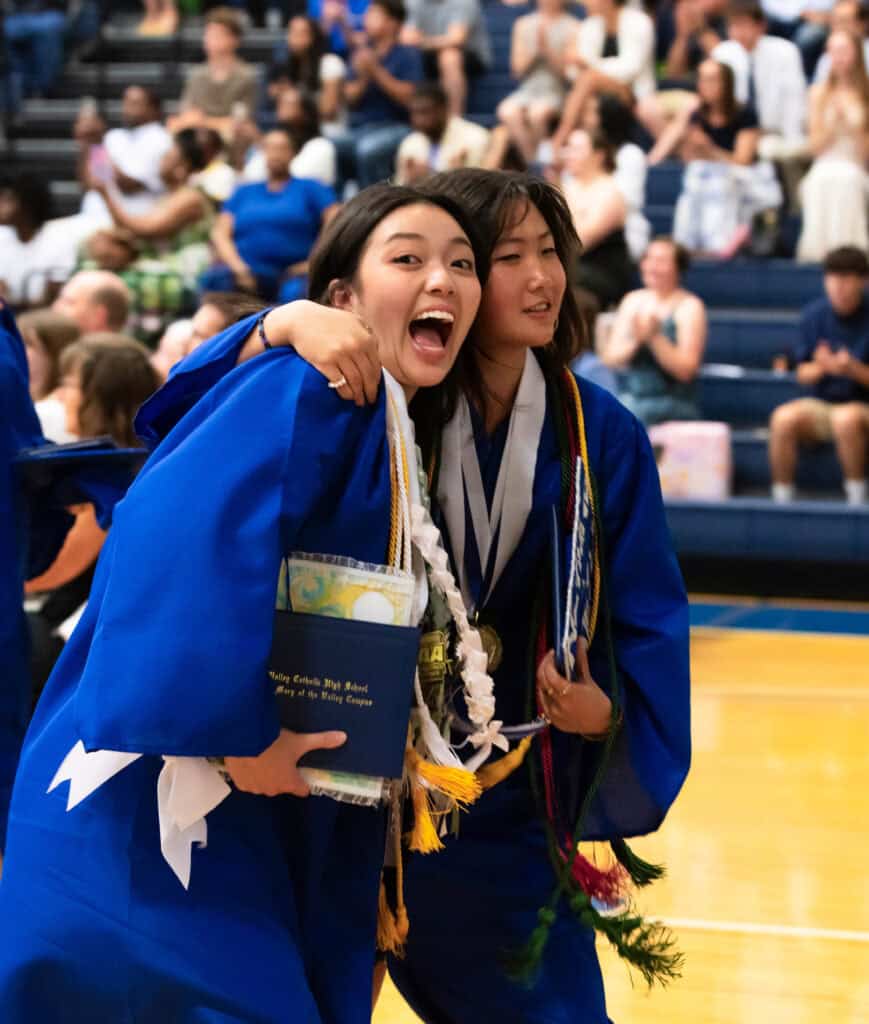 Grads excited hugging with diploma