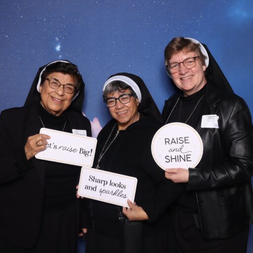 Sisters holding signs and smiling in the VCS Gala photo booth