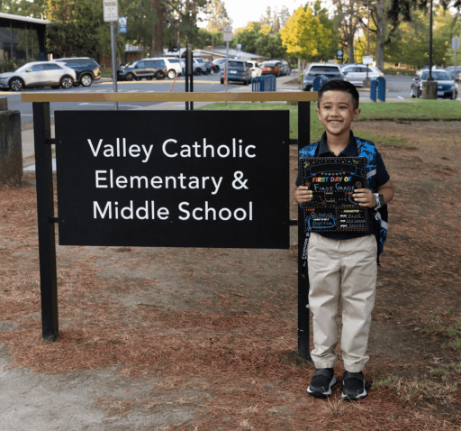 Elementary student on first week of school, posing near VC sign