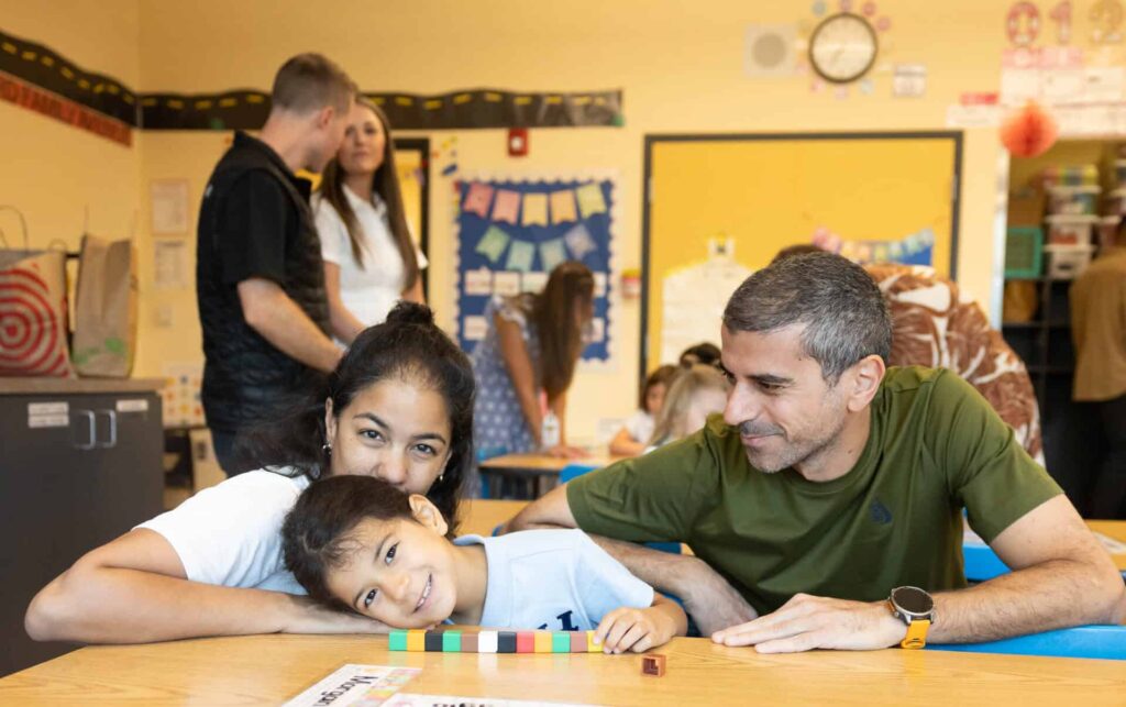 VCS First Week of School, student with parents at desk